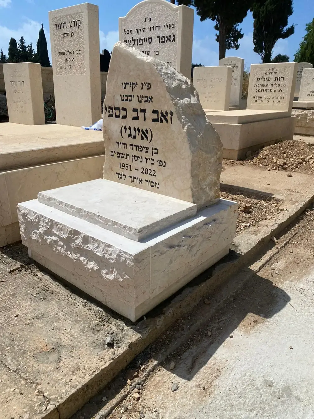 מצבת חצי מאבן טבעית בסגנון סלע עם כיתוב חרות