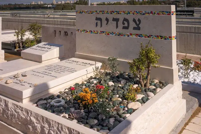 מצבה כפולה לבני זוג מעל שתי חלקות קבר צמודות