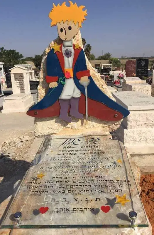 כיתוב עם אותיות מוזהבות על מצבה כהה
