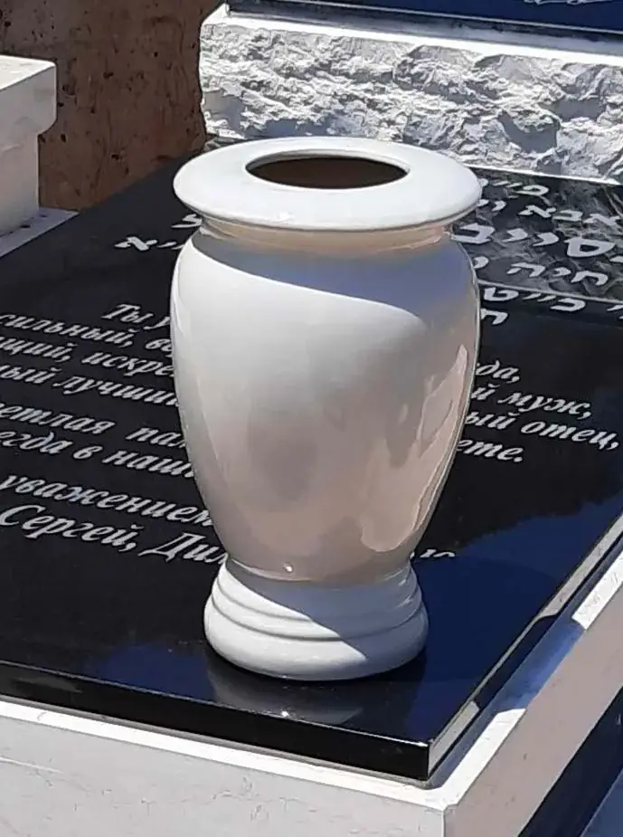 כד מתכת מותקן בצד המצבה
